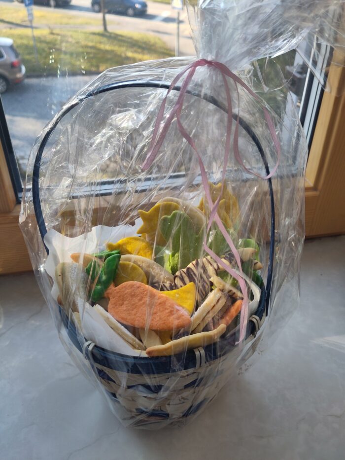 Eine mit Osterplätzchen gefüllte Plastiktüte steht auf einem Fensterbrett.