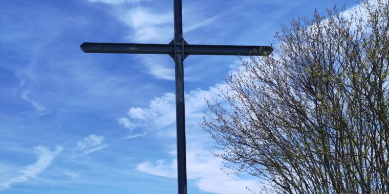 ein Kreuz inmitten eines grasbewachsenen Feldes